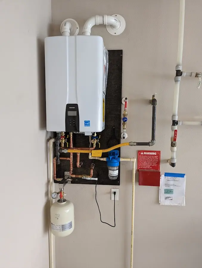 Professional plumber installing copper piping in a Mendota home